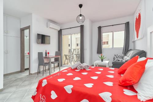 a bedroom with a red bed and a living room at Nerja Boutique 102 Deluxe in Nerja