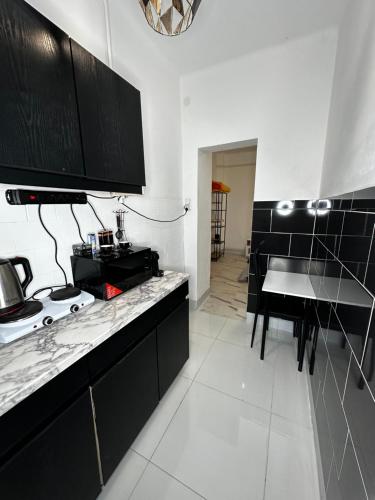 a kitchen with black cabinets and a table in it at Airport17 B&B in Vecsés