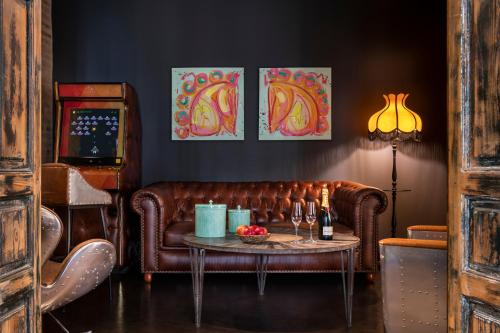 a living room with a brown leather couch and a table at Hotel Lobby in Seville