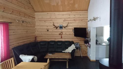 a living room with a black leather couch and a table at Fårgården Åsebol in Gårdsjö