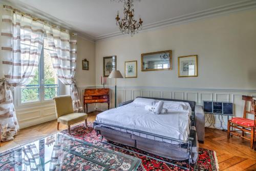 une chambre avec un lit, une chaise et une table dans l'établissement Appartement Tassigny - Welkeys, à Le Chesnay