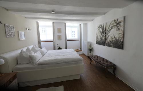 a white bedroom with a bed and a couch at Lüneburg Zentral in Lüneburg