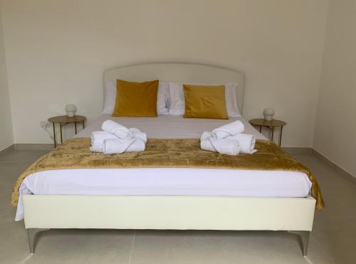 a bedroom with a large white bed with two towels at Cutelli Gold in Catania