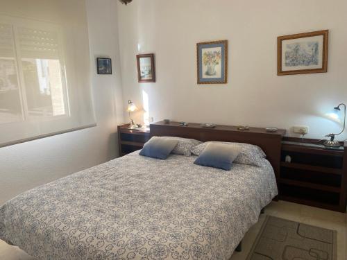 a bedroom with a bed with two blue pillows at Marina Bay Playa del Cristo in Estepona
