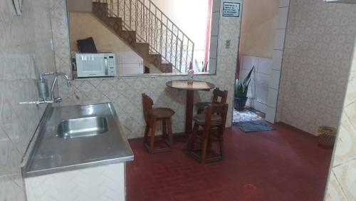 una cucina con un lavello e un tavolo con sedie di Hostel Por do Sol a Ouro Preto