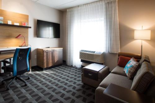 a hotel room with a couch and a desk and a computer at TownePlace Suites by Marriott Pittsburgh Cranberry Township in Cranberry Township