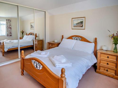 a bedroom with a large wooden bed with mirrors at 4 Bed in Shanklin IC068 in Shanklin