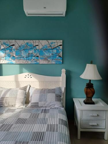 1 dormitorio con 1 cama con pared azul en Hermosa villa en punta cana, en Punta Cana