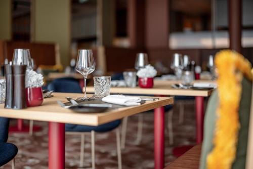 a table with wine glasses on it in a restaurant at Aqua Dome 4 Sterne Superior Hotel & Tirol Therme Längenfeld in Längenfeld