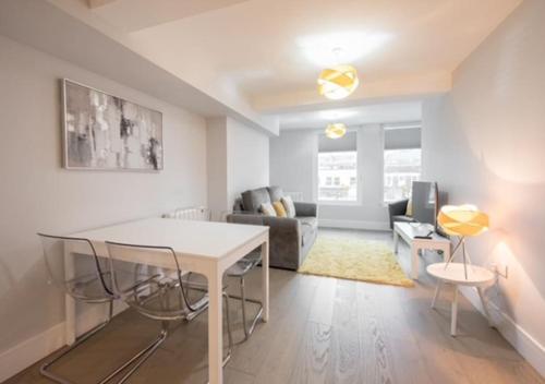 a living room with a table and a couch at Modern,central 1 bedroom flat in Brentwood