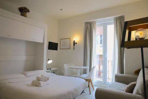 a hotel room with two beds and a window at Estudios Plaza Comendadora in Madrid