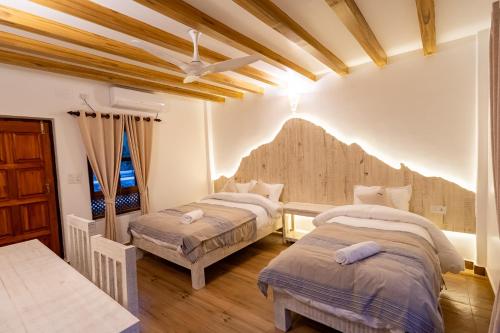 Duas camas num quarto com tectos em madeira em Purna em Pokhara