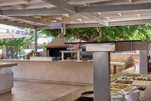 a restaurant with a counter with food on it at Atlantica Princess Hotel in Ixia