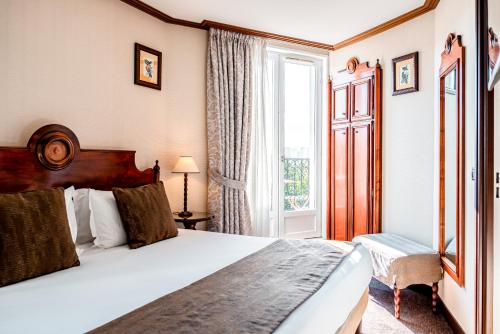 a hotel room with a bed and a window at Villa Montparnasse in Paris