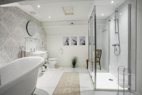ein Bad mit einer Badewanne, einer Dusche und einem WC in der Unterkunft The Sunset Retreat in Banbury