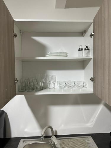 a kitchen with a sink and shelves with glasses at Terra Mia Residence in Mugnano di Napoli