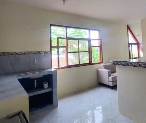 a kitchen with a sink and two windows at Casa Playa Los Marinos in Puerto Baquerizo Moreno