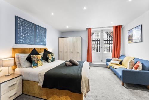 a bedroom with a bed and a couch at Modern Apartment in city Centre of Canterbury in Kent