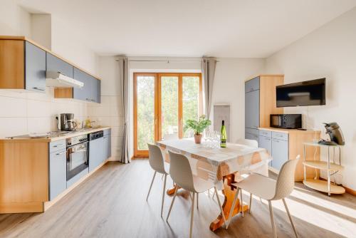 une cuisine avec une table et des chaises dans une pièce dans l'établissement SARL HARTWEG Les Amandiers, à Beblenheim