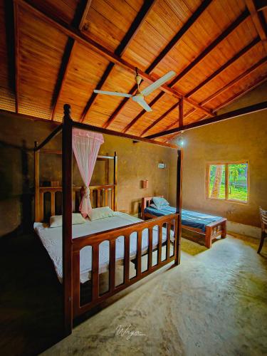 a bedroom with a bed and a ceiling fan at River Edge Safari Cottage in Udawalawe