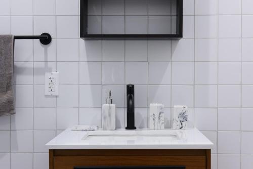 baño con lavabo y pared de azulejos blancos en 7-1 2BR 1Bath in Prime Park Slope en Brooklyn