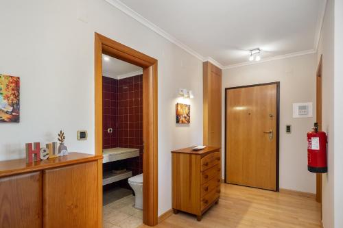 a bathroom with a toilet and a wooden door at Spacious 2BR apartment with free parking in Lisbon by Soulplaces in Lisbon