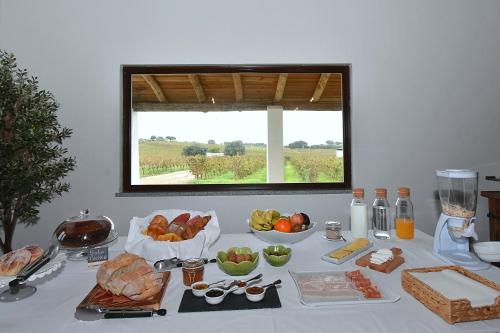 a table with food on it with a window at Turismo Rural Pedremoura in Vila Ruiva