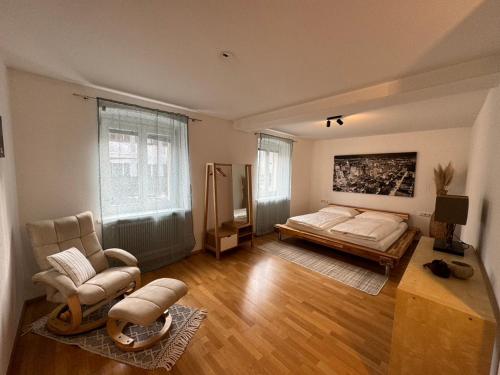 Geräumige Wohnung im Zentrum von Bludenz في بلودينز: غرفة نوم بسرير وكرسي في غرفة