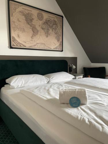 a large white bed with a towel on it at Hafen 17 Hotel Küche Bar in Kehl am Rhein