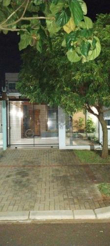 a house with a tree in front of it at Casa aconchegante in Cascavel