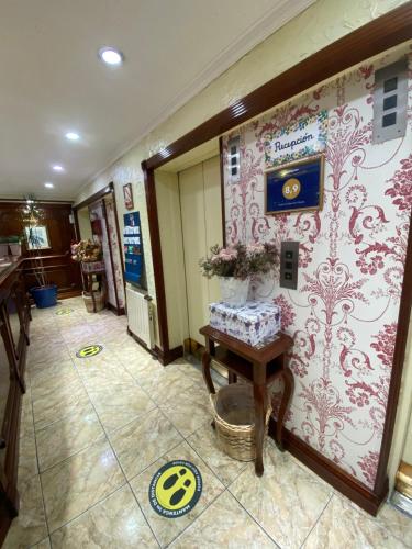 un couloir avec une chambre avec un mur recouvert de papier peint dans l'établissement Hotel Ciudad de Vitoria, à Santiago