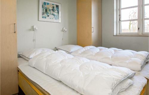 een groot bed met witte kussens erop bij Stunning Home In Sjlund With House Sea View in Hejls