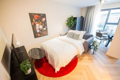 een slaapkamer met een bed en een rood tapijt bij Alphabet Apartments 1BR serviced apartments in Hilversum
