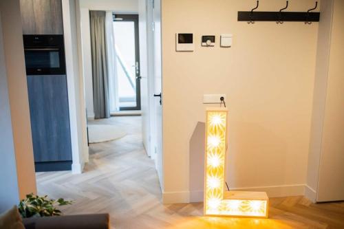 een verlichte stoel in een kamer met een gang bij Alphabet Apartments 1BR serviced apartments in Hilversum