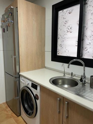 a kitchen with a sink and a washing machine at Hollywood POOL luxury in Mijas