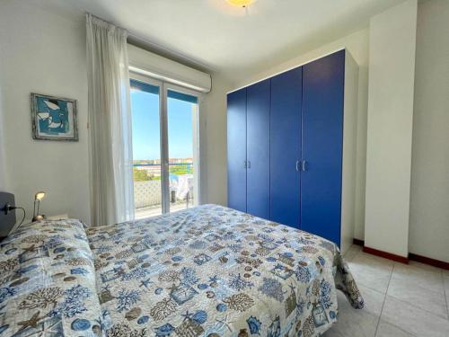 een slaapkamer met een bed en een groot raam bij Luminous flat in residence with pool in Veneto