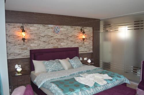 a bedroom with a bed and a brick wall at Hotel Goreme Sakura in Pamukkale