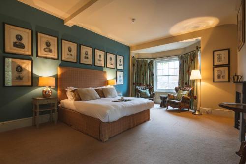 1 dormitorio con 1 cama grande y paredes azules en King John Inn, en Tollard Royal