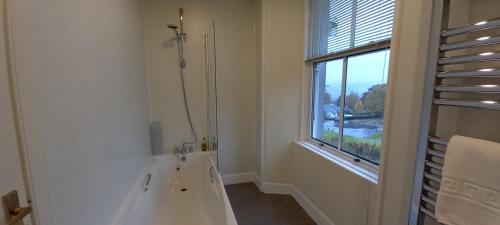a bathroom with a bath tub next to a window at Kinnaird House B and B in Pitlochry