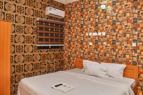 1 dormitorio con 1 cama con pared de ladrillo en GLAMOUR PARK'S HOTEL, ABUJA en Abuja