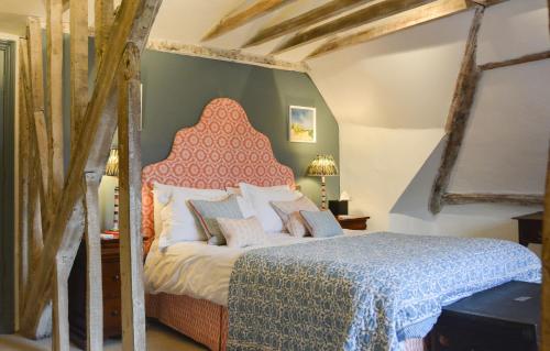 a bedroom with a bed with a red headboard at Crown Hotel in Southwold