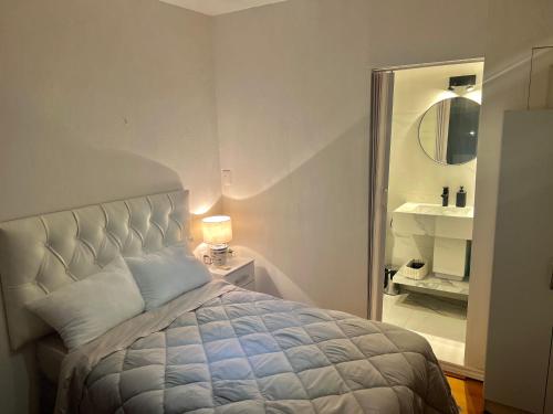 a bedroom with a bed and a bathroom with a mirror at Habitacion en Carrasco Sur, cerca del aeropuerto y la rambla in Montevideo
