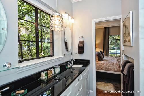 ein Bad mit einem Waschbecken und einem Spiegel in der Unterkunft The Home Collection CLT: 600 Hermitage in Charlotte