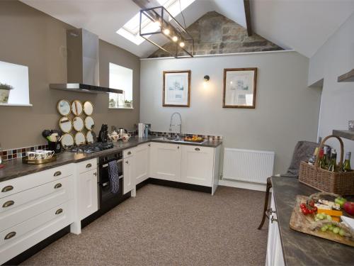 uma grande cozinha com armários brancos e um lavatório em 1 Bed in Pateley Bridge G0015 em Pateley Bridge