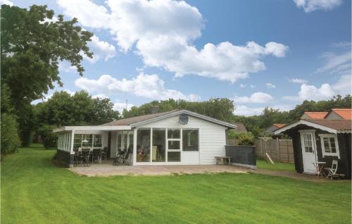 a small white house with a patio in a yard at Holiday Home Lærkevej Vinderup Xii in Vinderup