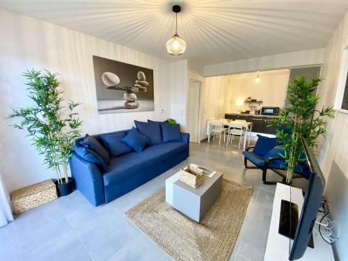 - un canapé bleu et des chaises dans le salon dans l'établissement CAPTAL beau 2 pièces cœur de ville parking terrasse, à La Teste-de-Buch