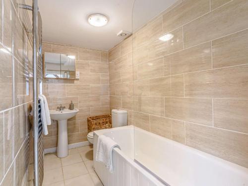a bathroom with a tub and a toilet and a sink at 2 Bed in Chippenham 77333 in Chippenham
