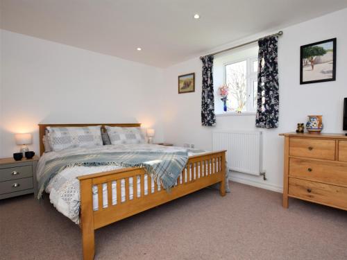 a bedroom with a wooden bed and a window at 3 Bed in Wellington 78595 in Sampford Arundel