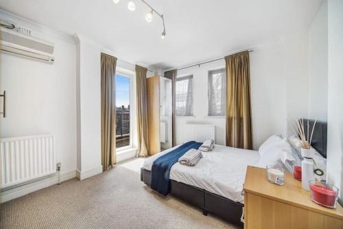 a bedroom with a bed and a desk and a window at Stunning 4-Bed Apartment in London