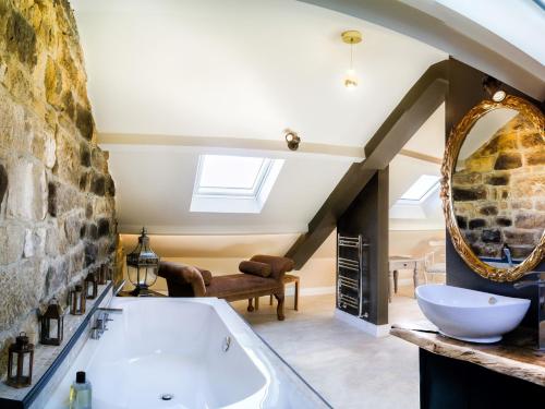 a bathroom with a large tub and a stone wall at 1 Bed in Pateley Bridge G0050 in Pateley Bridge